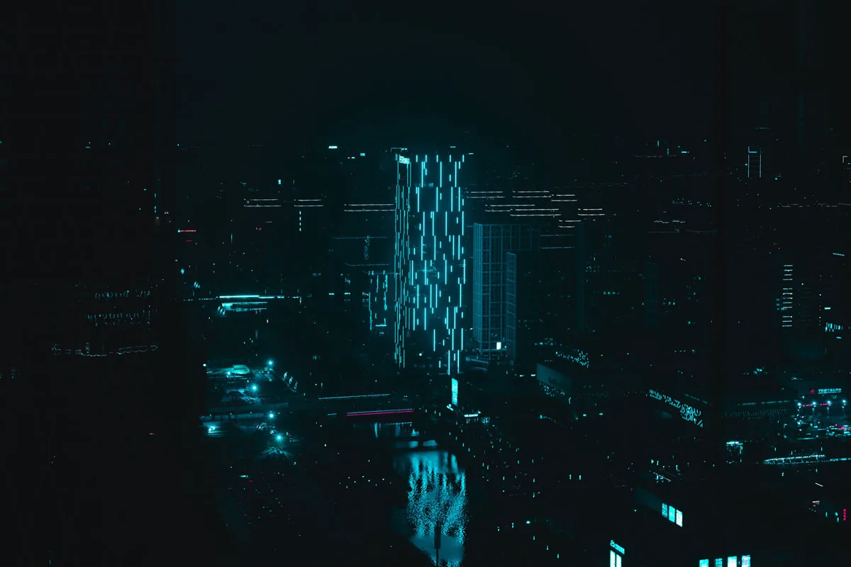 Nachtelijke skyline van bovenaf, met blauwe lichtlijnen op een torengebouw